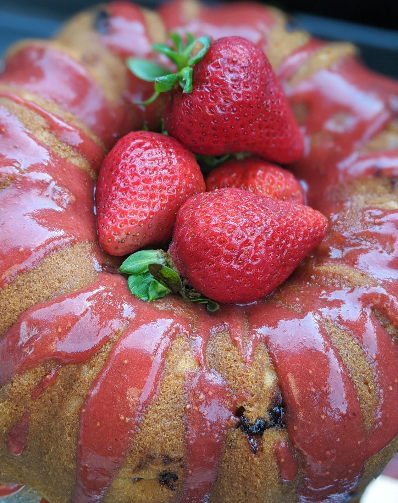 Strawberry glazed bundt cake topped with fresh strawberries