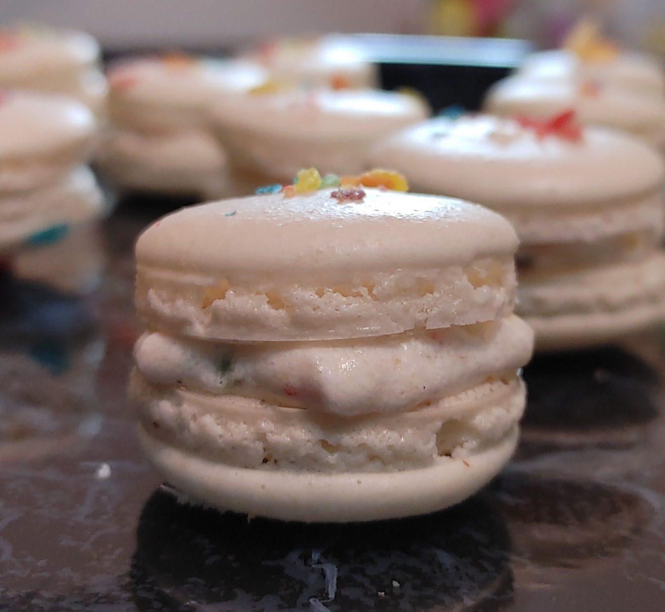 Stack of French macarons on a dark surface