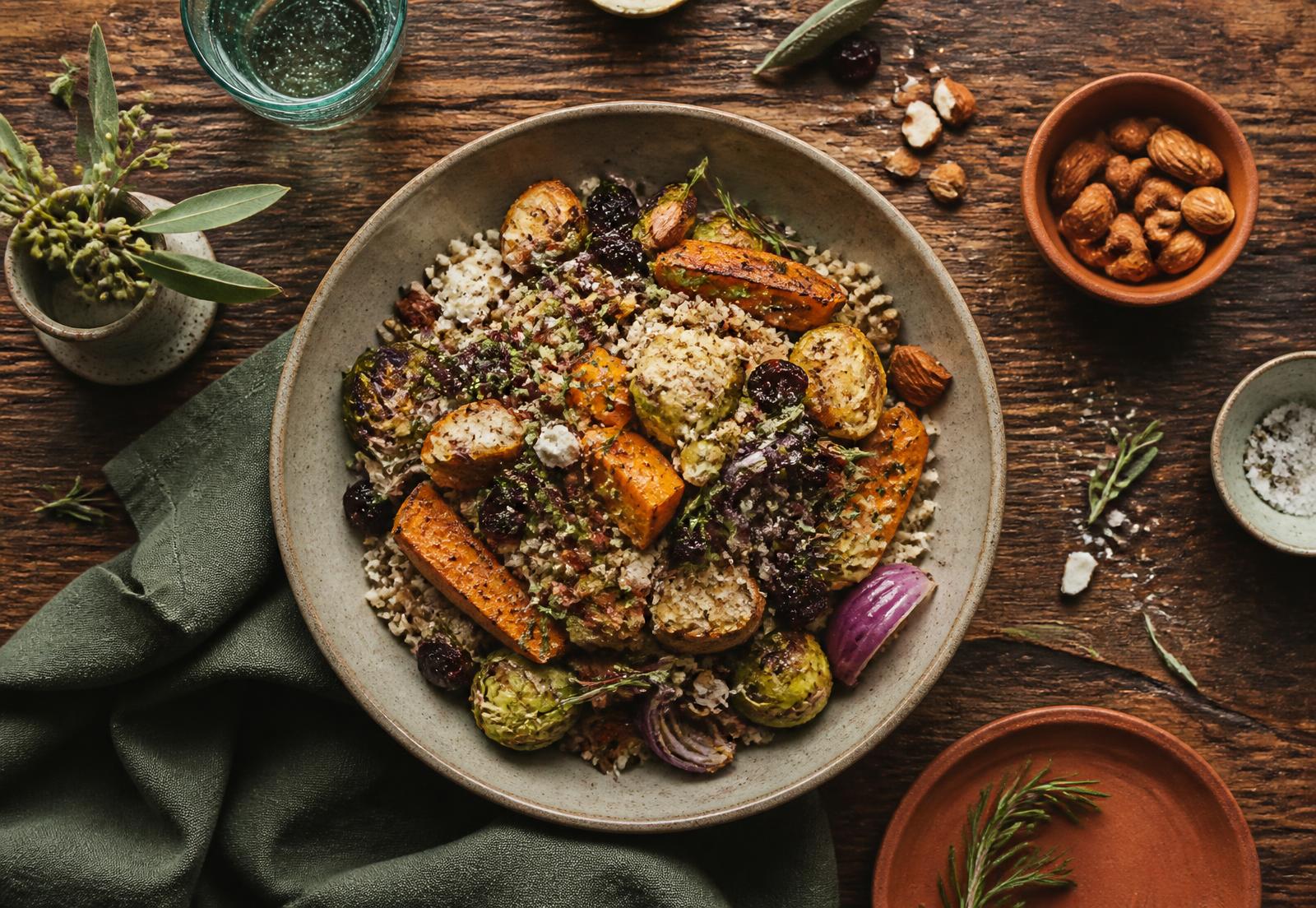 Overhead view of a nourishing grain and roasted vegetable bowl on a rustic table